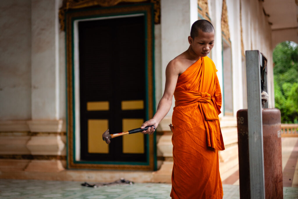 50mm lens used to capture Cambodian monks striking a bell from afar to avoid the intense sound.